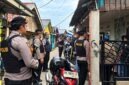 Petugas kepolisian dari Polres Tanjab Barat berjaga dengan senjata lengkap saat melakukan penggerebekan di salah satu rumah yang disinyalir sebagai sarang narkoba di kawasan Lorong Maut, Kuala Tungkal. (FOTO : Dok. LINTASTUNGKAL.COM)