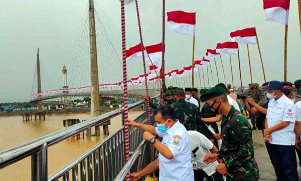 Gubernur Jambi Al Haris saat Memasang Bendera dalam Kegiatan Pengibaran Seribu Bendera di Jembatan Pedestrian Gentala Arasy, Minggu (15/08/21). FOTO : Diskominfo