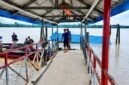 Kondisi halte penyeberangan atau dermaga apung di Desa Tanjung Senjulang, Kecamatan Bram Itam, Kabupaten Tanjung Jabung Barat, yang ambruk dan tenggelam sebagian ke dalam sungai. Sejumlah warga dan petugas tampak berada di lokasi jembatan penghubung untuk memantau situasi pasca-kejadian, Kamis (2/7). (Foto: Istimewa)