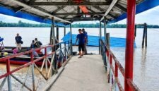 Kondisi halte penyeberangan atau dermaga apung di Desa Tanjung Senjulang, Kecamatan Bram Itam, Kabupaten Tanjung Jabung Barat, yang ambruk dan tenggelam sebagian ke dalam sungai. Sejumlah warga dan petugas tampak berada di lokasi jembatan penghubung untuk memantau situasi pasca-kejadian, Kamis (2/7). (Foto: Istimewa)