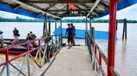 Kondisi halte penyeberangan atau dermaga apung di Desa Tanjung Senjulang, Kecamatan Bram Itam, Kabupaten Tanjung Jabung Barat, yang ambruk dan tenggelam sebagian ke dalam sungai. Sejumlah warga dan petugas tampak berada di lokasi jembatan penghubung untuk memantau situasi pasca-kejadian, Kamis (2/7). (Foto: Istimewa)
