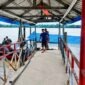 Kondisi halte penyeberangan atau dermaga apung di Desa Tanjung Senjulang, Kecamatan Bram Itam, Kabupaten Tanjung Jabung Barat, yang ambruk dan tenggelam sebagian ke dalam sungai. Sejumlah warga dan petugas tampak berada di lokasi jembatan penghubung untuk memantau situasi pasca-kejadian, Kamis (2/7). (Foto: Istimewa)