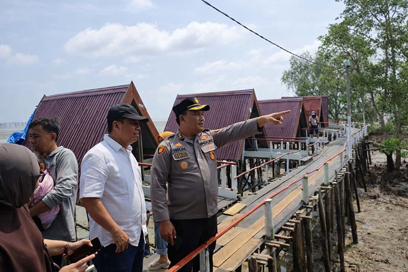 Kapolres Tanjab Barat, AKBP M. Kuswicaksono, S.I.K., M.H. (kanan), didampingi Wakil Bupati Tanjab Barat, Dr. H. Katamso (tengah), meninjau langsung area bibir pantai di Hutan Mangrove Pantai Kelapa usai mengikuti Anev Ops Ketupat 2026 bersama Kapolri, Selasa (24/3). Peninjauan ini dilakukan untuk memastikan prosedur pengamanan wisata air berjalan maksimal guna mencegah fatalitas kecelakaan laut. (FOTO : RES TJB)
