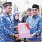 Bupati Tanjab Barat H. Anwar Sadat Saat Menyetahkan Satyalencana Karya Satya 30 tahun kepada Dartono (Kabag Sarpas Setda Tanjab Barat) pada upacara peringatan Hari KORPRI ke-51 tahun 2022 di halaman Kantor Bupati Tanjab Barat, Selasa (29/11/22). FOTO : Prokopim

