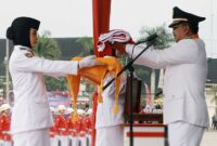 Bupati Tanjung Jabung Barat Drs H Anwar Sadat, M. Ag menyerahkan Duplikat Bendera Merah Putih untuk dikibarkan, Kamis (17/8/23). FOTO : FM