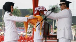 Bupati Tanjung Jabung Barat Drs H Anwar Sadat, M. Ag menyerahkan Duplikat Bendera Merah Putih untuk dikibarkan, Kamis (17/8/23). FOTO : FM