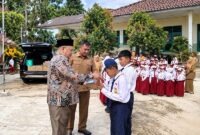 Wakil Ketua II DPRD Kabupaten Tanjung Jabung Barat, Hasan Basyri Harahap (kiri depan), memberikan bantuan secara simbolis kepada siswa saat mengunjungi SMP 34 dan SD 173 Terjun Jaya, Senin (7/9/2026). (FOTO : Dok. HUMAS)
