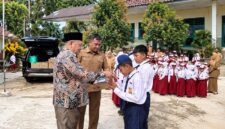 Wakil Ketua II DPRD Kabupaten Tanjung Jabung Barat, Hasan Basyri Harahap (kiri depan), memberikan bantuan secara simbolis kepada siswa saat mengunjungi SMP 34 dan SD 173 Terjun Jaya, Senin (7/9/2026). (FOTO : Dok. HUMAS)