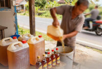 Ilsutrasi Seseorang Penjual Tuak Menuang Ke Ember'. FOTO : LT