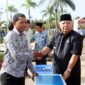 FOTO : Bupati Tanjung Jabung Barat Dr. H. Safrial Menyerahkan Bantuan Kepada Perwakilan Pedangan Yang Menrima Usai Upacar Gabungan TNI, Polri, dan Aparatur Sipil Negara (ASN) di Halaman Kantor Bupati, Selasa (17/03/20)