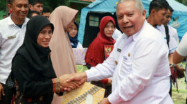 FOTO : Bupati Dr. H. Safrial Menyerhkan Bantuan Sosial Program Sembako dalam bentuk Bantuan Pangan Non Tunai (BPNT) Kepada Salah Satu Penerima di Lapangan Kantor Camat Pengabuan, Rabu (18/03/10).