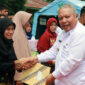 FOTO : Bupati Dr. H. Safrial Menyerhkan Bantuan Sosial Program Sembako dalam bentuk Bantuan Pangan Non Tunai (BPNT) Kepada Salah Satu Penerima di Lapangan Kantor Camat Pengabuan, Rabu (18/03/10).