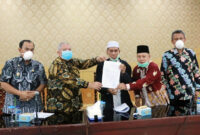 FOTO : Bupati Dr. H. Safrial MS, Wakil Bupati H. Amir Sakib, Ketua MUI Drs. H. Mahyuddin Arif, M.Ud dan Ketua FKUB H. A. Satar AG, S.Ag Mengangkat Bokumen Kesepakatan Bersama Terkait Upaya Pencegahn Corona Covid-19 di Balai Pertemuan Kantor Bupati, Kamis (26/03/20).