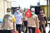 FOTO : Kapolres Tanjab Barat AKBP Guntur Saputro Saat Menyambagi Salah Satu Warga Ketika Baksos Pembagian Sembako bersama BRI Unit Kuala Tungkal, Selasa (21/04/20).