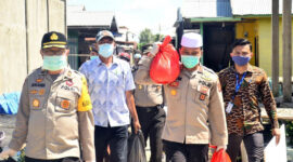 FOTO : Kapolres Tanjab Barat AKBP Guntur Saputro Saat Menyambagi Salah Satu Warga Ketika Baksos Pembagian Sembako bersama BRI Unit Kuala Tungkal, Selasa (21/04/20).