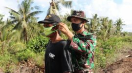 FOTO : Satgas TMMD 108 Kodim 0419/Tanjab saat Memasangkan Masker ke Warga