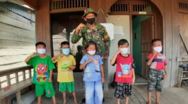 FOTO : Satgas TMMD 108 Kodim 0419/Tanjab saat Memasangkan Masker ke pada Anak-Anak di Desa Labuan Pering.