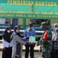 FOTO : Satgas TMMD membatu membagikan 20 buah Al Qur’an Juz Amma untuk anak-anak, Desa Labuhan Pering, Rabu (22/07/20).