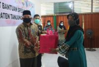 FOTO : Bupati Tanjab Barat H. Safrial Saat Menyerahkan Bantuan Spesifik Perempuan dan Anak dari Kementrian P3A di Aula Kantor Dinas P3AP2KB, Kamis (01/10/20).