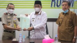 FOTO : Bupati Tanjab Barat KH. Anwar Sadat Saat Menerima Pemyerahan 35 Sertifikat Tanah Milik Pemkab dari Kepala BPN Supriadi di ruang rapat Bupati, Senin (29/03/21).