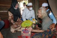 FOTO : Bupati H. Anwar Sadat dan istri di kediaman Nenek Sapniah di Kelurahan Teluk Nilau, Kecamatan Pengabuan, Jum'at (02/04/21).