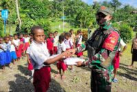 Danpos Kibay Letda Inf Daniel saat membagikan seragam dan sarana sekolah siswa SD Inpres di Kampung Kibay Distrik Arso Timur Kab. Keerom, Papua, Sabtu (24/07/21). FOTO : SATGASPAMTAS
