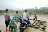 Banjir Merlung Memutus Lalulintas Jalan Warga Terpaksa Membuat Tandu Untuk Menyeberangkan Kendsraaan Bermotor.