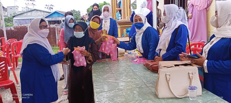 Nurhayati Ketua DPC IWAPI Tanjab Barat bagikan bahan pokok kepada Warga yang sudah di Vaksinasi. FOTO : Bas
