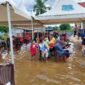 Warga sabar menunggu panggilan untuk vaksin diatas genangan Air, Sabtu (18/12/21)
