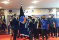 H Syarif Fasha menyerahkan bendera Pataka Partai Nasdem kepada Riano Jayawardhana Nst Ketua DPD Partai Nadem Tanjab Barat, di Tungkal Hotel, Rabu (12/1/2022).