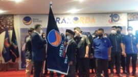 H Syarif Fasha menyerahkan bendera Pataka Partai Nasdem kepada Riano Jayawardhana Nst Ketua DPD Partai Nadem Tanjab Barat, di Tungkal Hotel, Rabu (12/1/2022).