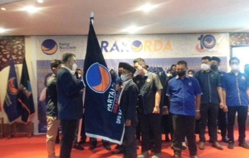 H Syarif Fasha menyerahkan bendera Pataka Partai Nasdem kepada Riano Jayawardhana Nst Ketua DPD Partai Nadem Tanjab Barat, di Tungkal Hotel, Rabu (12/1/2022).