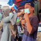 Ketua PWI Tanjab Barat Rita Anggraini memasangkan Masker ke Pedagang Jalan Nasional, Rabu (9/2/22). FOTO : ABAS
