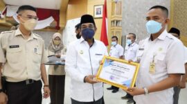 H Anwar Sadat meyerahkan Piagam penghargaan kepada Camat Kecamatan Bram Itam Hendri Fonda. FOTO : Istimewa