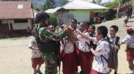Satgas Pamtas Yonif R 142/KJ Bagikan Tas Sekolah Untuk Anak SD Karubaga