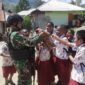 Satgas Pamtas Yonif R 142/KJ Bagikan Tas Sekolah Untuk Anak SD Karubaga