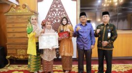 Terima Penghargaan dari OASE KIM, Bupati Tanjabbar Sampaikan Ucapan Selamat ke Yuliawati. FOTO : Ist