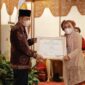Momen Saat Wakil Gubernur Jambi Drs. H. Abdullah Sani menyerahkan Piagam Penghargaan dari OASE-KIM kepada Yuliawati (Bunda Uly). FOTO : Ist.