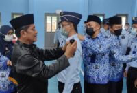 Kalapas Kelas IIB Kuala Tungkal Sugiharto memasang tanda pangkat PNS yang memperoleh kenaikan pangkat reguler, Jum'at (13/5/22). FOTO : Humas