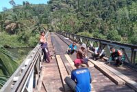 TNI Bersama Warga Bahu Membahu Perbaiki Jembatan yang Rusak. FOTO : PENREM
