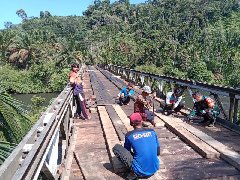 TNI Bersama Warga Bahu Membahu Perbaiki Jembatan yang Rusak. FOTO : PENREM
