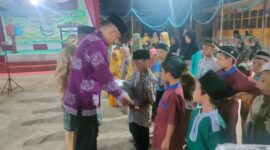 Camat Bram Itam Hendri Fonda didampingi Kades Kemuning Abdul Ghani saat menyerahkan bantuan Pendidikan bagi Pelajar, Sabtu (4/6/22) FOTO : Ist