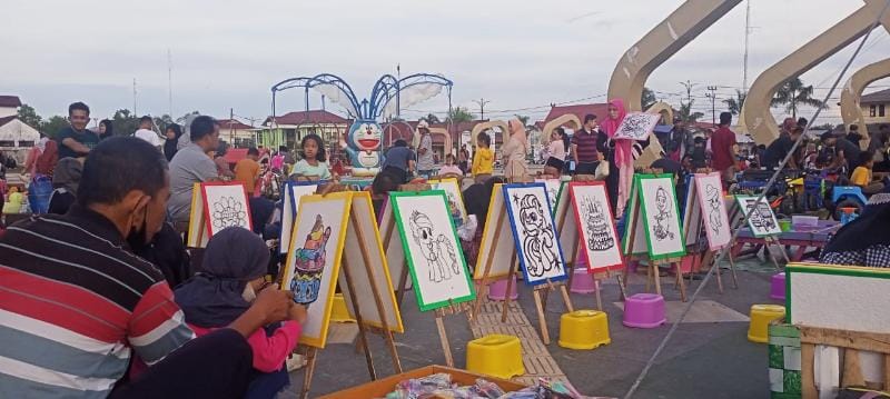 Pengunjung mayoritas Anak - Anak sedang menikmati Wahana permainan mewarnai di Alun - Alun Kota Kuala Tungkal, Minggu (24/7/22). FOTO : lintastungkal