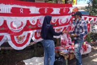 Yuni Penjual Bendera Merah Putih Replika Asal Kecamatan Soreang, Bandung, Jawa Barat saat melayani Pembeli, Selasa (9/8/22). FOTO : LT