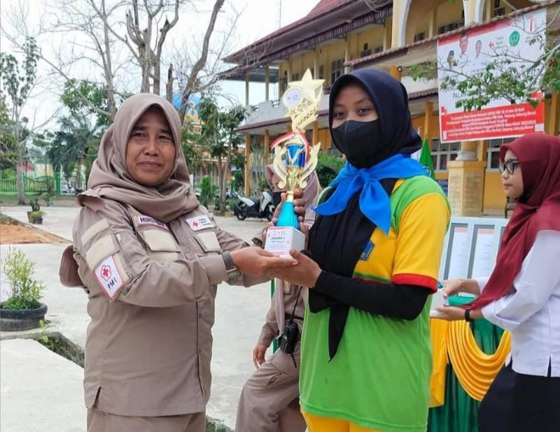 Ketua Tim PMR Madya SMP Negeri 2 Kuala Tungkal saat menerima tropi Juara pertama. FOTO : SMPN 2 Kuala Tungkal