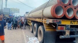 Anggota Satlantas Polres Muaro Jambi Dibantu Warga Mengevakuasi Korban dibawah Kolong Truk Treler. [FOTO : Humas PMJ].