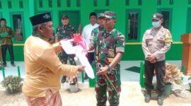 Secara simbolis, Dandim 0419/Tanjab Letkol Kav Muslim Rahim Tompo, SH., M. Si menyerahkan Kunci Gedung Madrasah Nurul Falah kepada Kepala Desa Sungai Papauh. FOTO : Pentjb