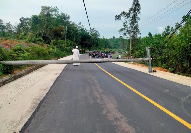 Kondisi Dua Tiang Listrik milik PLN Tumbang ke Jalan di Wilayah Sungai Toman Kabupaten Tanjung Jabung Timur, Minggu (6/11/22). FOTO : Ist