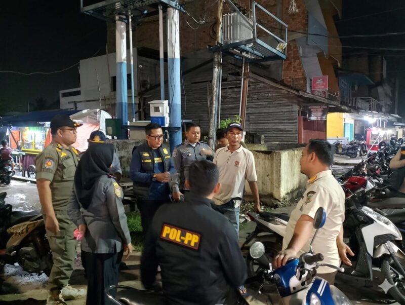Keterangan Foto:
Petugas gabungan dari Dinas Perhubungan (Dishub) Tanjung Jabung Barat dan Satpol-PP sedang memberikan pengarahan serta melakukan pendataan kepada seorang juru parkir di salah satu titik strategis di Kuala Tungkal, Jumat malam (6/3/26). FOTO: LT