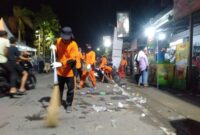 Petugas kebersihan dari DLH Tanjung Jabung Barat membersihkan sampah yang ditinggalkan warga usai menyaksikan Festival Arakan Sahur, Sabtu (1/4/23) Malam. FOTO : LT 